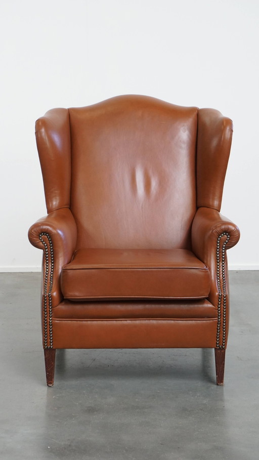 Fauteuil à oreilles en cuir de bœuf de couleur cognac de style anglais avec clous décoratifs