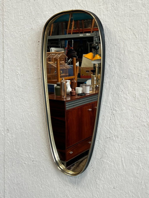 Een leuke vintage spiegel in ovale/druppelvorm. Gemaakt in Scandinavië (mogelijk Deens) in de 1960's. Voorzien van een kunststof