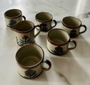 Vintage enameled stoneware cups and milk jug with floral pattern
