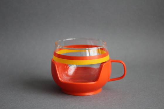 Image 1 of 12 vintage glazen theekopjes met geel-oranje strepen en oranje plastic houders.