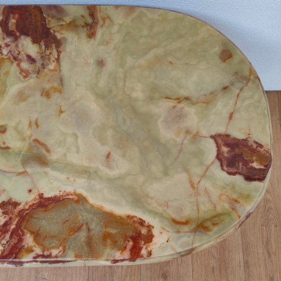 Image 1 of Table basse ovale de style Hollywood Regency avec plateau en marbre et piètement en laiton.