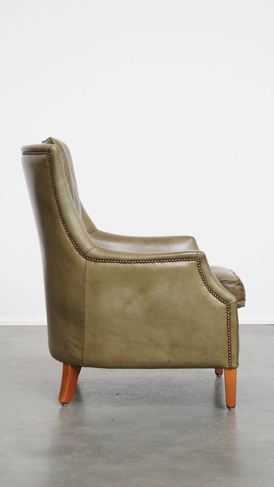 Image 1 of Poltrona in pelle di mucca verde oliva rifinita con chiodi decorativi