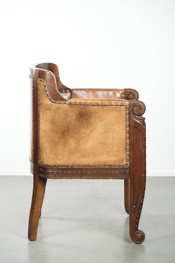 Image 1 of Antique armchair of sheepskin and wood with decorative nails and beautiful woodwork