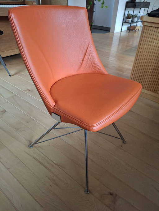 Orangefarbener Lederstuhl mit Metallbeinen