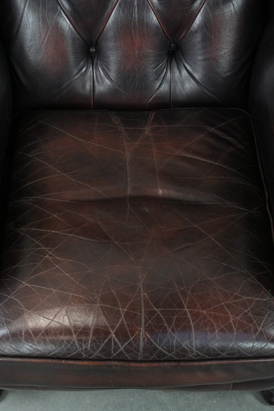Image 1 of Poltrona Chesterfield con braccioli in pelle bovina marrone, in classico stile inglese.
