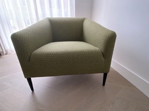 Sijben armchair in moss green fabric with matte black steel legs.