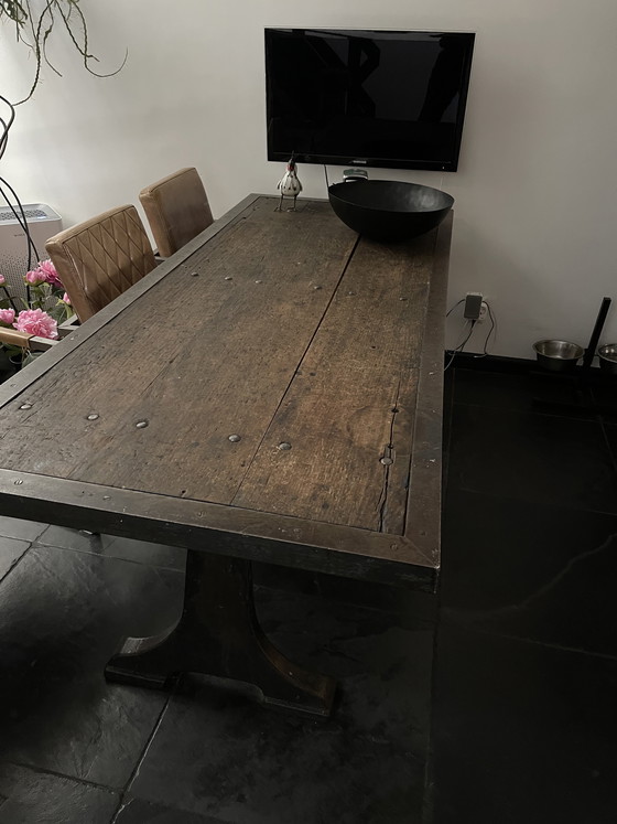 Image 1 of Industriele eettafel van oude werkbank met gietijzer onderstel y gelaste randen