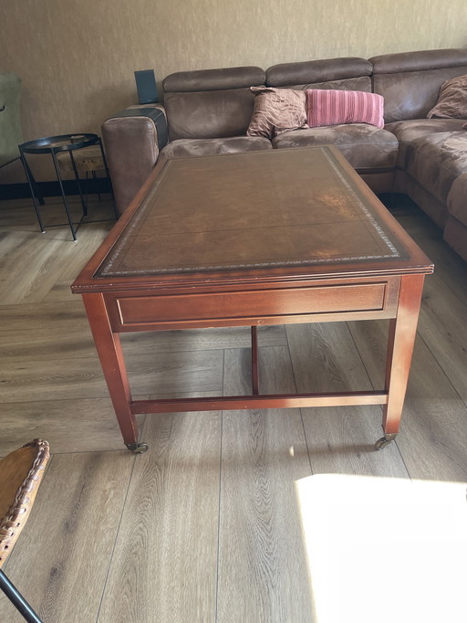 ornate English style coffee table with a brown/red leather top with 4 drawers.
