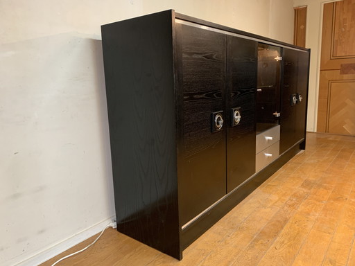 Credenza de madera pintada de negro con elementos plateados