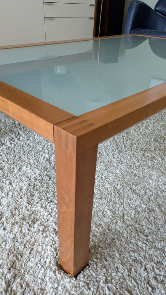 Image 1 of cherry wood red coffee table with sleek glass top from 1996