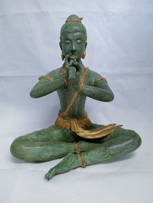 Estatua de una figura tocando la flauta, pátina verde