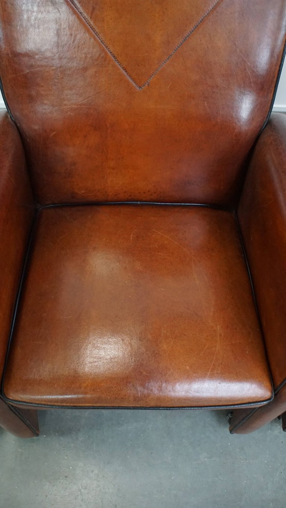 Image 1 of 4 x Vintage schapenleren eetkamerstoel met zwarte biezen op wieltjes