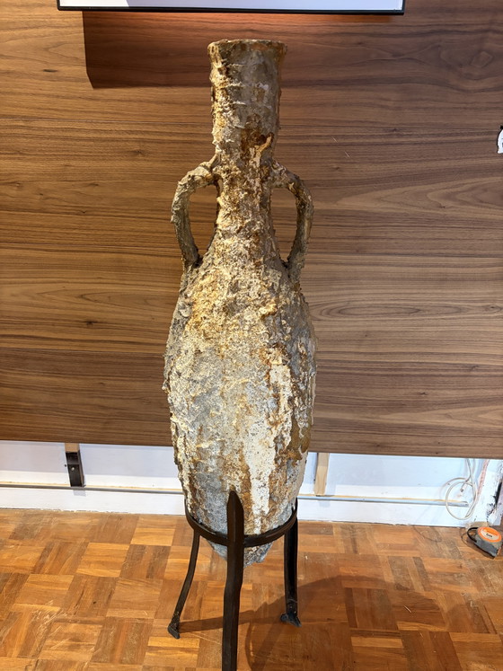 Image 1 of Echte römische Amphore aus einer Meeresgrabung, komplett mit ihrem schmiedeeisernen Sockel.


