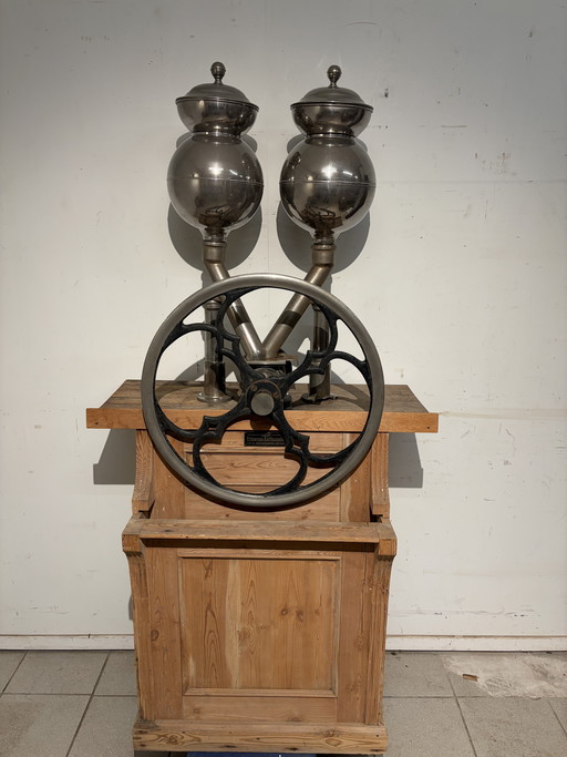 Raro macinacaffè di grandi dimensioni con grande ruota in ferro e base in pino; i cassetti sono di epoca successiva.