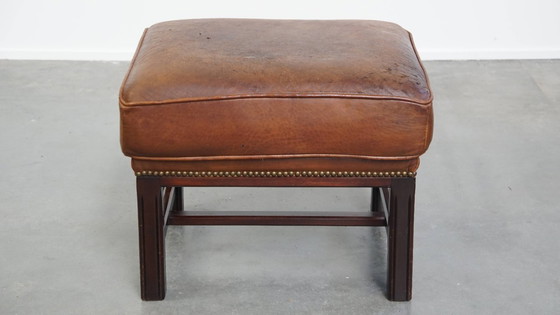 Image 1 of Hocker in pelle di pecora con struttura in legno e finitura con rivetti decorativi