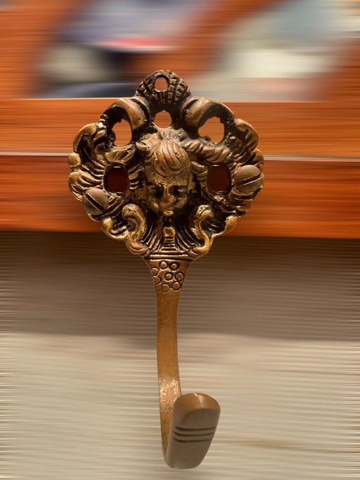 Art Nouveau coat rack with 4 sculpted brass hooks, floral carving and elaborate chasing as well as gold-plated accents