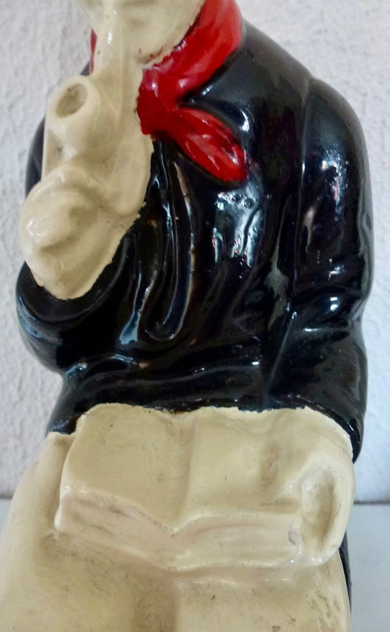 Image 1 of A set of decorative bookends depicting an elderly couple sitting on chairs.