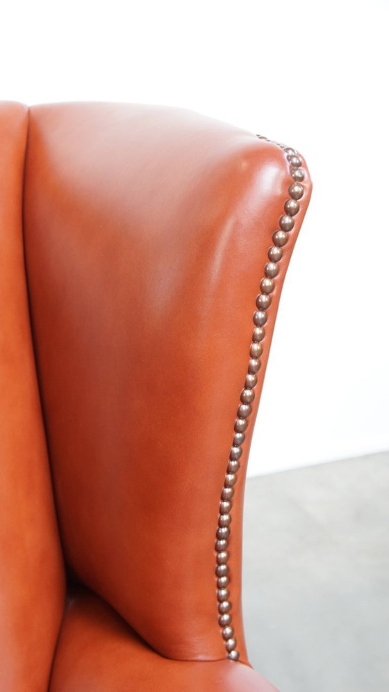 Image 1 of Elegante en comfortabele gladde Engelse rundleren chesterfield oorfauteuil met sierlijke pootjes