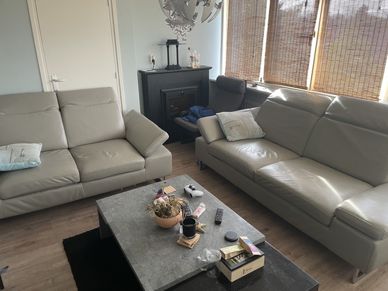 Image 1 of Grijze leren bank met verstelbare hoofd-arm leuningen.