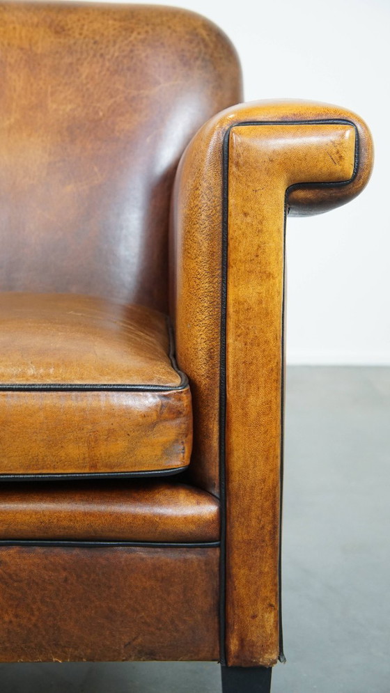 Image 1 of Sillón de diseño Art Déco en buen estado, con un acabado elegante y ribetes negros.