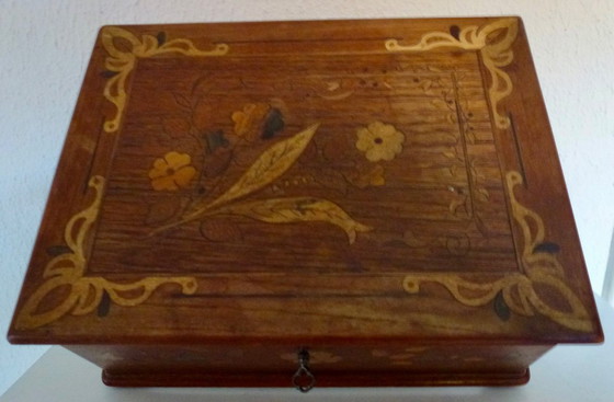 Image 1 of Una scatola di legno d'epoca con intarsi floreali