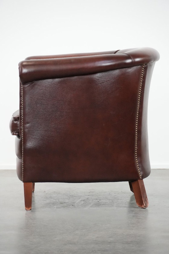 Image 1 of Sillón club de piel de vaca en buen estado, de un lujoso color rojo/marrón.