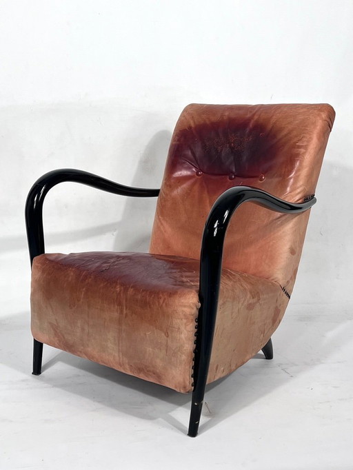 Sillón escultórico italiano de mediados de siglo XX, tapizado en cuero y madera curvada, de los años 50.