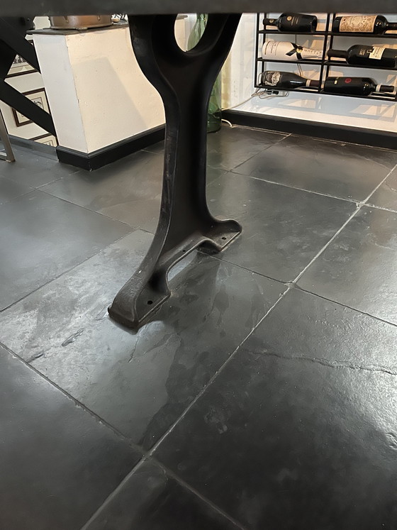 Image 1 of Industriele eettafel van oude werkbank met gietijzer onderstel y gelaste randen