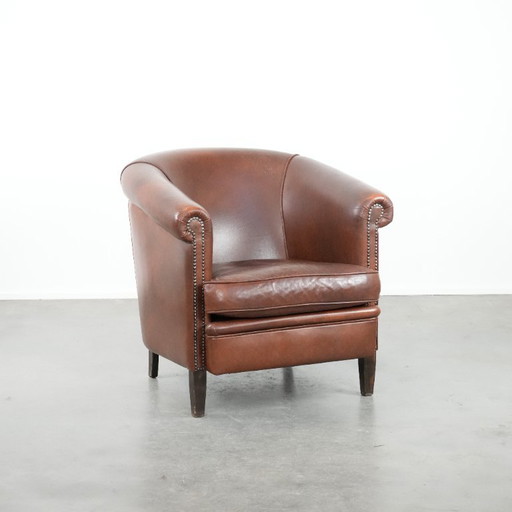 Cognac-colored cowhide leather club armchair in English style with a luxurious appearance