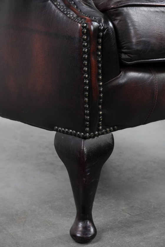 Image 1 of Poltrona Chesterfield con braccioli in pelle bovina marrone, in classico stile inglese.