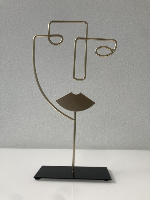 Sculpture moderne en fil de fer représentant un visage stylisé