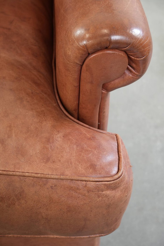 Image 1 of Poltrona a orecchioni color cognac chiaro, rivestita in pelle bovina, dal caratteristico look inglese.