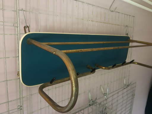 Perchero de pared original de los años 50, color azul petróleo, con estructura tubular dorada.