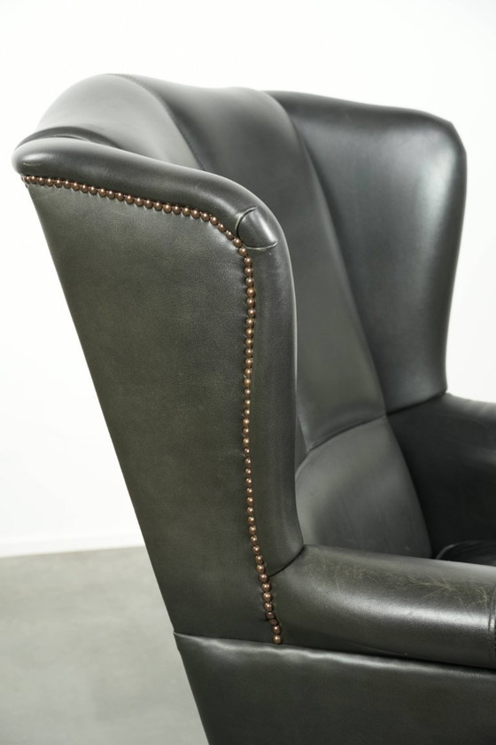Image 1 of Zwarte rundleren oorfauteuil in een klassiek Engelse stijl