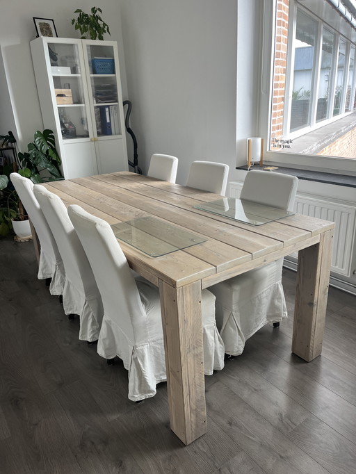 Robuuste massief houten eettafel met 6 bijpassende stoelen.