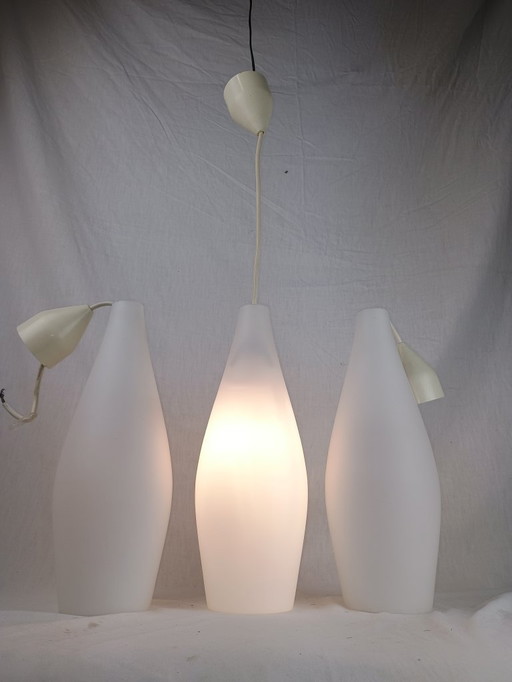 Elegant and timeless, this set of three original Holmegaard glass pendant lamps