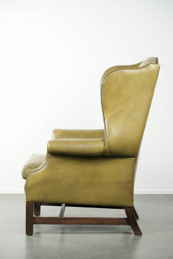 Image 1 of Fauteuil à oreilles ancien et élégant en cuir de vachette vert, de style classique de maison de campagne anglaise.