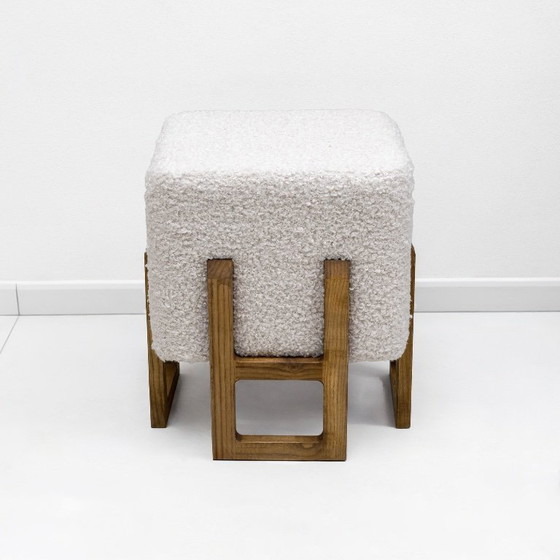 Image 1 of Een paar Italiaanse modernistische krukjes van essenhout, bekleed met witte boucléstof.