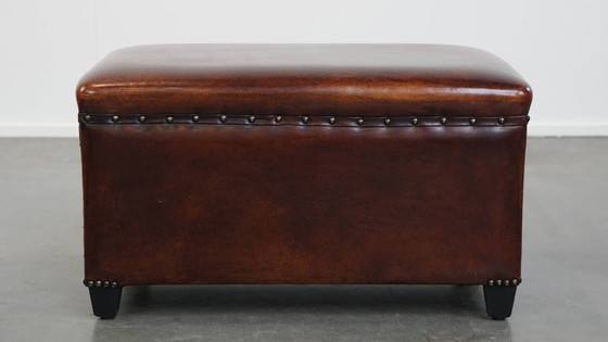 Image 1 of Cognac-kleurige schapenleren hocker met siernagels