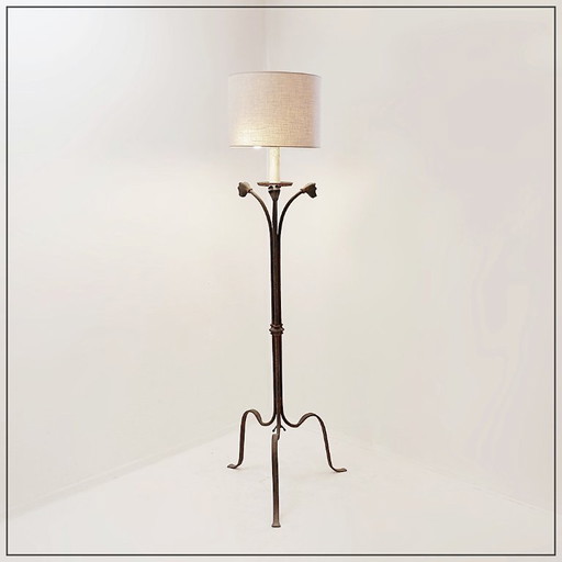 Wrought-iron tripod floor lamp adorned with stylized animal heads