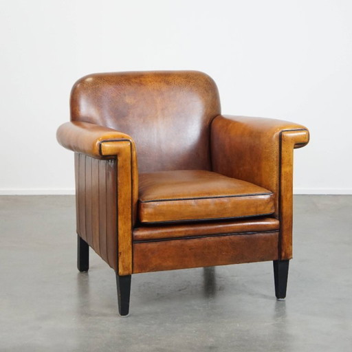 Sillón de diseño Art Déco en buen estado, con un acabado elegante y ribetes negros.