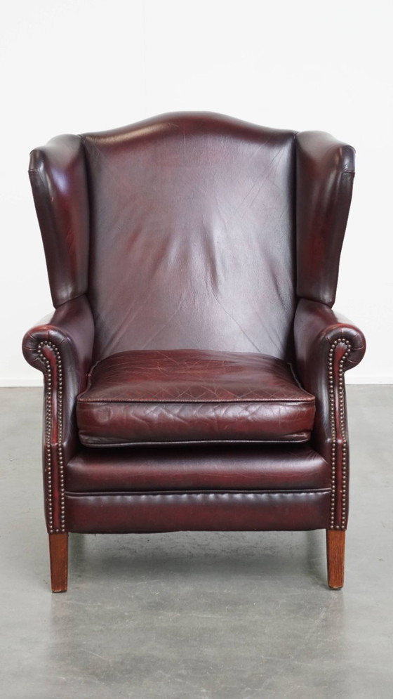 Image 1 of Bordeauxrode Rundleren Oorfauteuil in Engelse Stijl