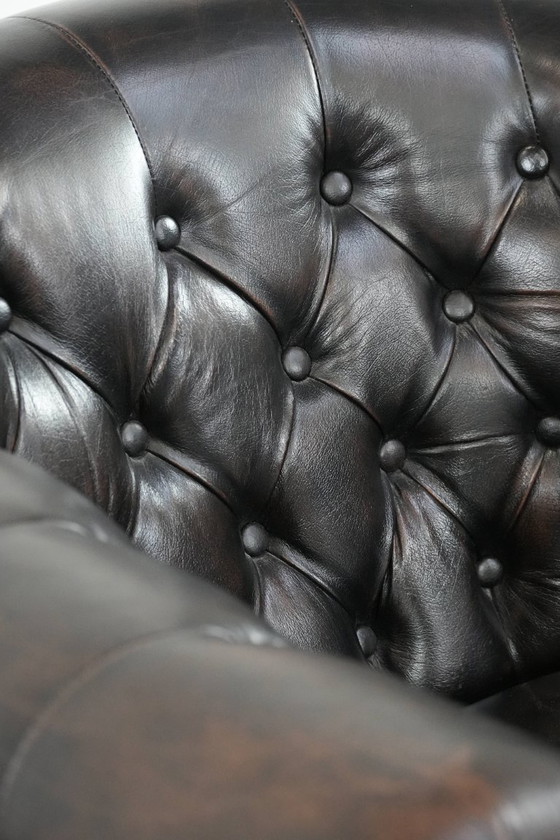 Image 1 of Donkere luxe rundleren Chesterfield clubfauteuil in Engelse stijl, afgewerkt met siernagels