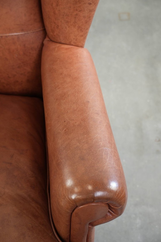 Image 1 of Poltrona a orecchioni color cognac chiaro, rivestita in pelle bovina, dal caratteristico look inglese.