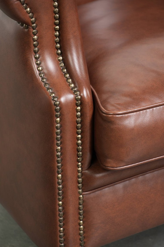 Image 1 of Bellissima e comoda poltrona club in stile inglese, rivestita in pelle di vacchetta color cognac.