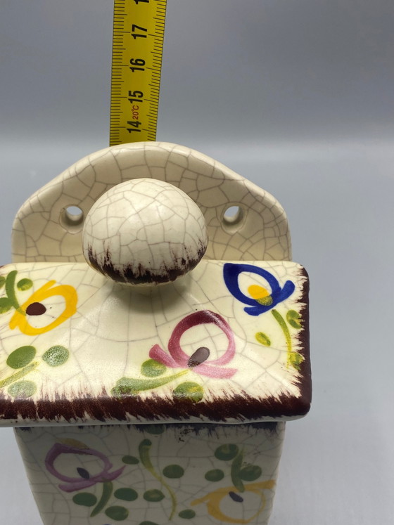 Wandgemonteerde keramische zoutpot met gebarsten emaille en veelkleurige bloemversiering – Frankrijk, circa (photo 8 of 8)
