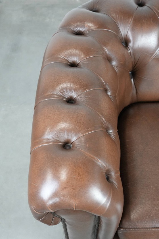 Image 1 of Impresionante sillón Chesterfield de piel de vaca marrón al estilo inglés, acabado con clavos decorativos.