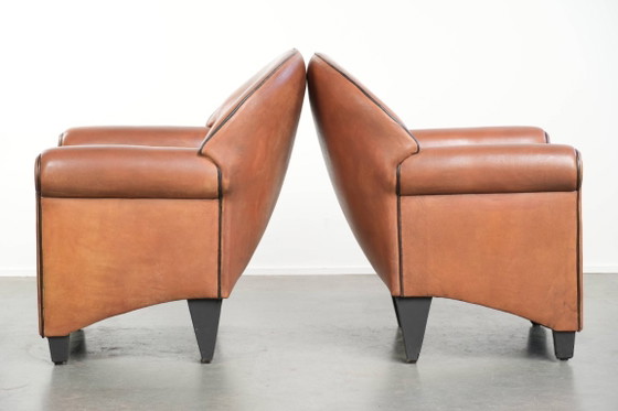 Image 1 of 2 poltrone di design Bart van Bekhoven in pelle di pecora con schienale arrotondato e profili neri.