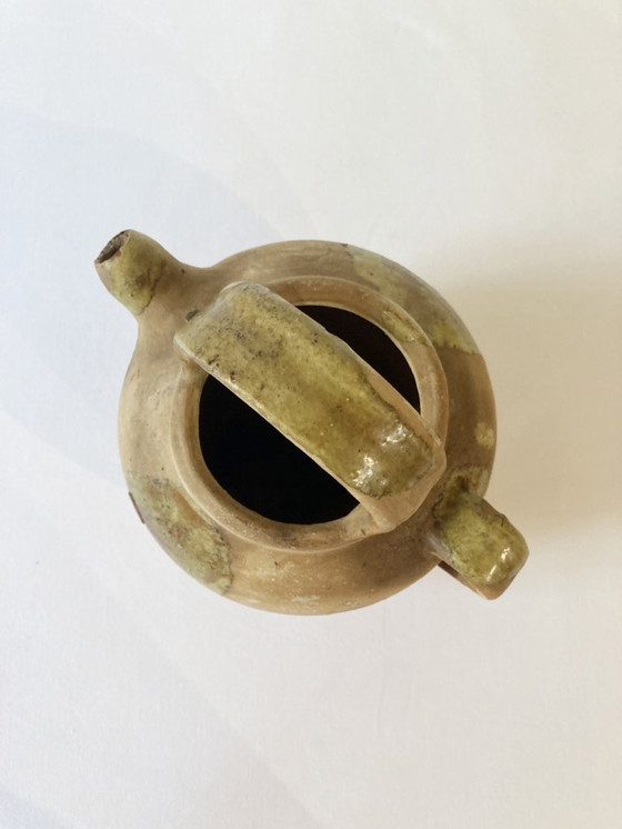 Image 1 of Klein Provençaals kannetje in de vorm van een geit, gemaakt van crèmewit en lichtgroen geglazuurd aardewerk.