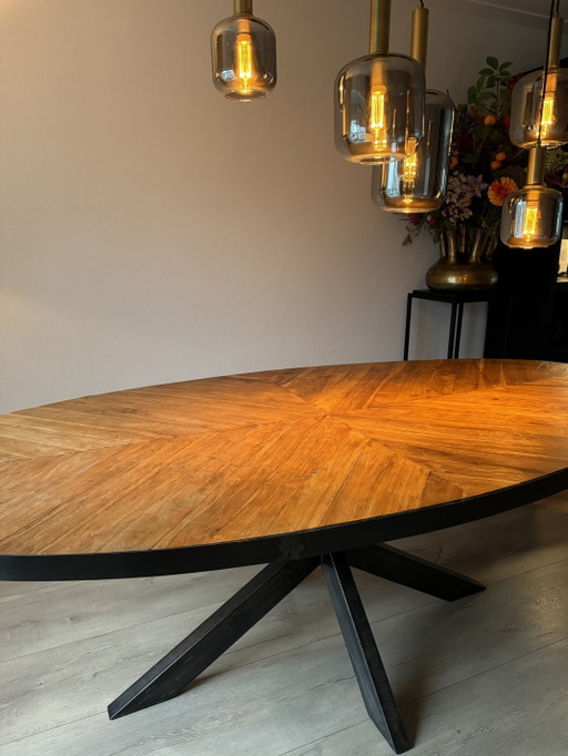 Mesa de comedor ovalada en espiga con lateral industrial y pata de estrella de acero